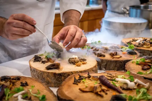 Mesa com pratos de gastronomia local sendo preparados, representando o tema de experiências autênticas.