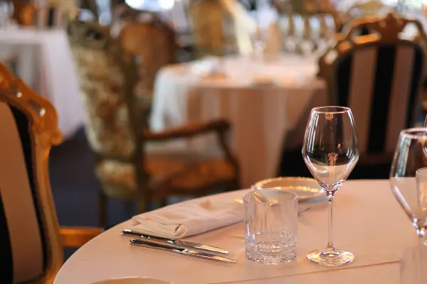 Mesa elegante com taça de vinho, representando experiências gastronômicas em hotéis